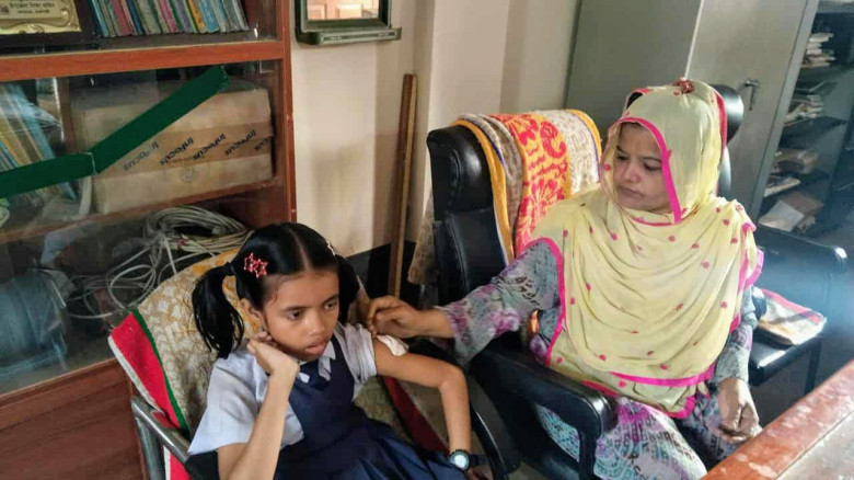 বাগমারা'য় প্রাথমিক বিদ্যালয়ের দপ্তরীর হাতে শিশু শি...